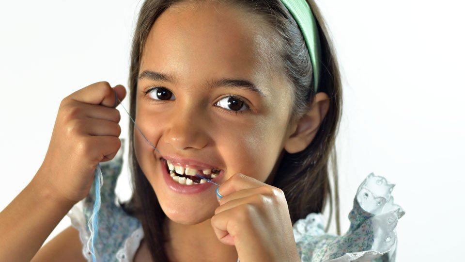 Child Flossing her teeth
